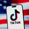 TikTok logo on a cellphone superimposed over an American flag