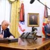 Donald Trump sits at his desk signing an executive order.