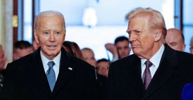 Joe Biden, left, stands next to Donald Trump, right. Both are wearing black jackets.