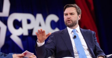 JD Vance wears a slate gray suit and light blue necktie while speaking at CPAC.