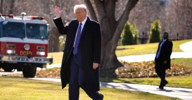 President Donald Trump waves as he walks to the Marine One presidential helicopter.