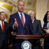 Backed by fellow Senate Republicans, Majority Leader John Thune, R-S.D., speaks to reporters.