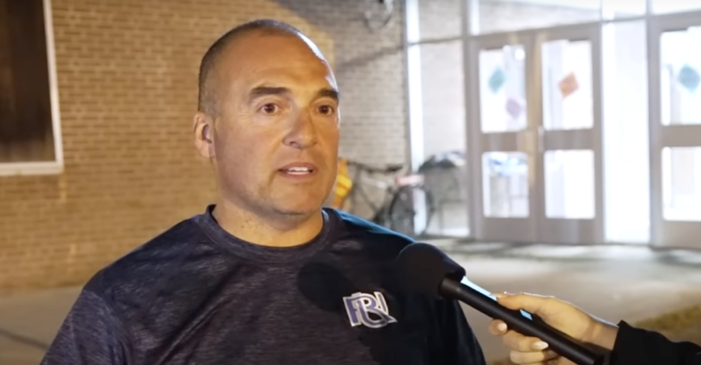 concerned father speaks in front of a school